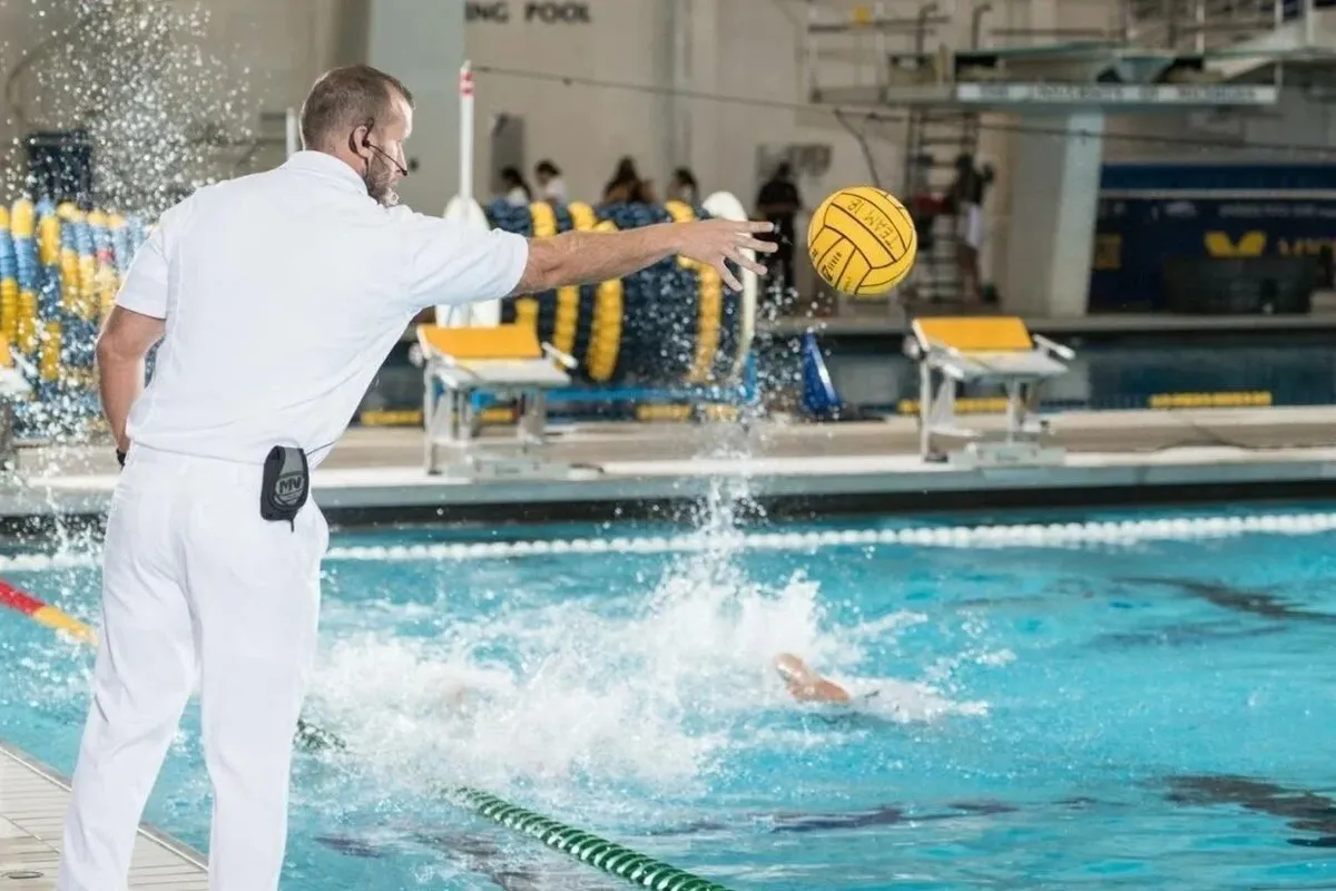 Water polo referee reviewing their four-domain self-assessment on a phone